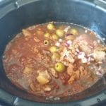Voeg de specerijen en het kokende water aan de slowcooker toe