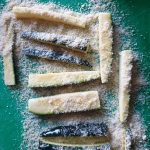 Strooi wat paneermeel over de frietjes heen