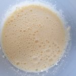 met een handmixer eieren en roomkaas schuimig kloppen