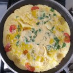 De omelet moet licht stevig worden voordat je de plakjes mozzarella er op legt
