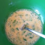 Eieren met water, peper en zout en basilicum goed loskloppen