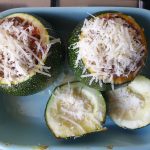 Strooi de kaas over de courgettes en het kapje