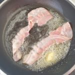 plakjes spek in de pan leggen en het vuur iets hoger draaien