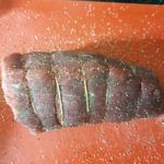 Rode snijplank met rosbief en peper en zout