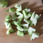Houten snijplank met in stukjes gesneden broccoli steel