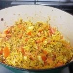 Braadpan met gele bloemkoolrijst en stukjes tomaat