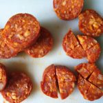 Witte snijplank met in stukjes gesneden chorizo