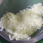 Geraspte koolrabi in een metalen zeef