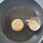 Haal de kookring er voorzichtig af en keer de blini. Gebruik de kookring voor de volgende blini