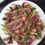Drizzle pesto over de salade en de ossenhaas