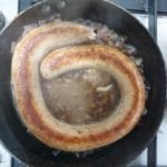Koekenpan met gebruinde worst