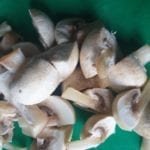 Groene snijplank met plakjes champignons