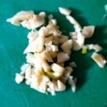 Groene snijplank met stukjes knoflook
