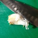 Groene snijplank met teentje knoflook