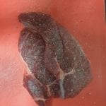 Snijplank met vlees met peper en zout