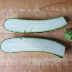 Houten snijplank met halve courgettes met zout erover