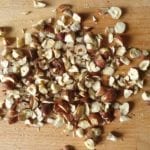Houten snijplank met grof gehakte hazelnoten