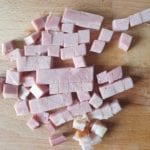 Houten snijplank met blokjes ham