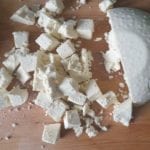 Houten snijplank met in blokjes gesneden paneer