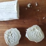 Houten snijplank met plakken geitenkaas