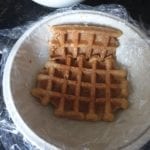 Stukken in koffie gedoopte wafel in een stenen kom die bedekt is met vershoudfolie