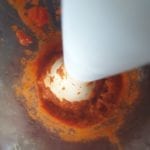Handblender in beker met tomatensaus
