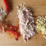 Snijplank met fijngesneden knoflook, sjalot en cayenne peper