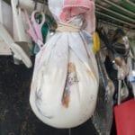 Met yoghurt gevulde dichtgebonden theedoek opgehangen aan een haak