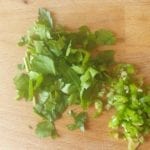 Houten snijplank met fijngesneden cayenne peper en platte peterselie