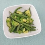 Kom met sperzieboontjes met avocado blokjes