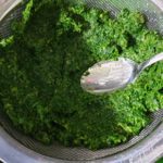Met een lepel zoveel mogelijk water uit de spinazie duwen
