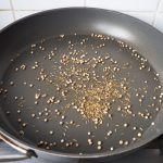 Korianderzaadjes en komijn in hele hete pan roosteren