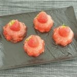 Aardbeien gelatine puddinkjes op een zwarte schaal